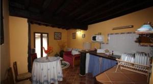 cocina con mesa en el centro de una habitación en Apartamentos La Zurdina, en Mogarraz