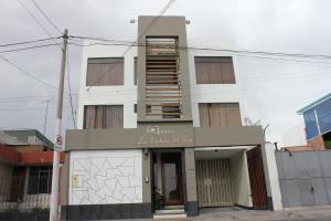 a tall white building with a staircase on it at La Almohada del Rey in Arequipa