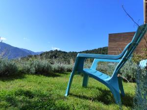 a blue chair sitting in the grass at Maison d'Hôtes Zella in Bains de Guitera