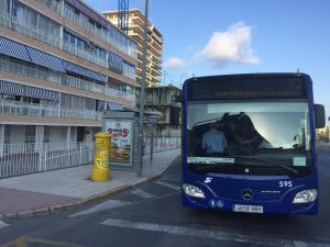 a blue bus is parked at a bus stop at First line Apartment in Alicante