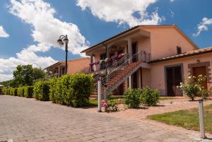 un edificio con una escalera y flores en él en Villaggio Le Querce, en Sorano
