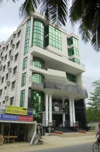 a building with a person sitting in front of it at Hotel Supreme in Sylhet