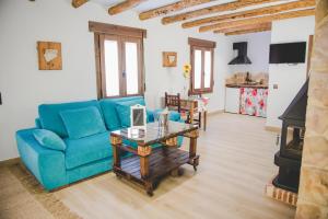 a living room with a blue couch and a table at Navazos loft in Benaocaz