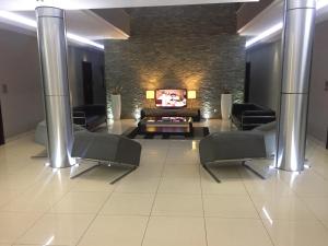 a living room with a fireplace and a tv at Hotel Amirana in Chimoio