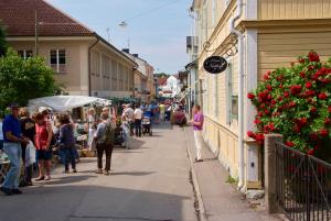 a group of people walking down a street in a town at 27ans Nattlogi in Vadstena