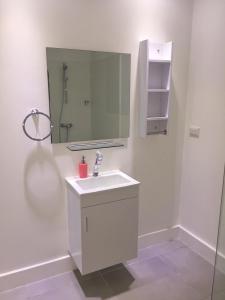 a white bathroom with a sink and a mirror at Las Islas Condo #1 in Palm-Eagle Beach
