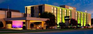 a hotel building with a neon sign in front of it at Radisson Hotel Fort Worth North-Fossil Creek in Fort Worth