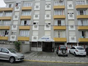 un bâtiment avec des voitures garées devant lui dans l'établissement Lexus Residence Apto 304, à Florianópolis