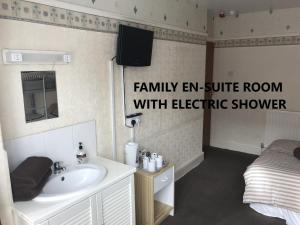 a bathroom with a sink and a bed at Coco Beach Hotel in Blackpool