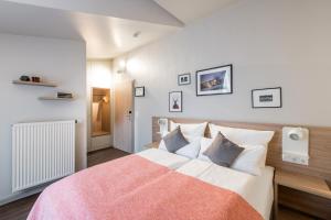 a bedroom with a large bed with a pink blanket at stattHotel Weimar in Weimar