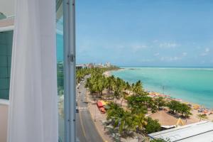 uma vista para uma praia com palmeiras e para o oceano em Hotel Sete Coqueiros em Maceió