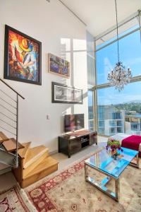 sala de estar con cama y ventana grande en The Quadrant Apartments, en Ciudad del Cabo