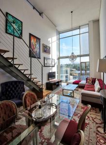 sala de estar con mesa de cristal y escalera en The Quadrant Apartments, en Ciudad del Cabo