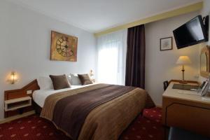 pokój hotelowy z łóżkiem i telewizorem w obiekcie The Originals City, Hôtel du Faucigny, Cluses Ouest w mieście Scionzier