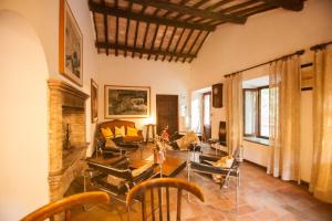 a living room with couches and a table and chairs at Agriturismo biologico il Molinaccio al Rio Chiaro in Civitella dʼAgliano