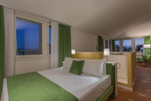 a bedroom with a large bed with green and white pillows at Battistero Residenza d'Epoca in Pistoia +65 photos