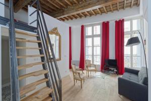 sala de estar con escalera y cortinas rojas en L'Argenterie, Apparts de charme, parking gratuit, en Montpellier