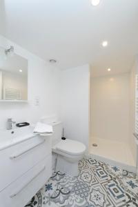 Un baño blanco con inodoro y lavabo. en L'Argenterie, Apparts de charme, parking gratuit, en Montpellier 23 fotos más