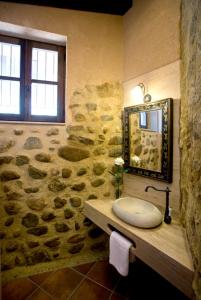 a stone bathroom with a sink and a mirror at Rincón de San Cayetano in Villalpando