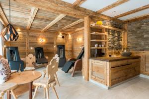 バディーアにあるHotel Cavallinoの木製の壁、テーブルと椅子が備わる客室です。