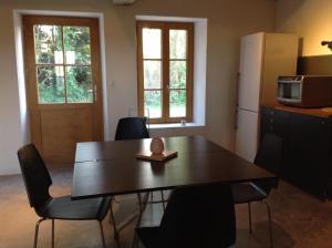 a kitchen with a table and chairs and a refrigerator at L'Epine in Saint Remy du Val