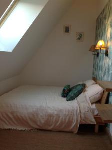 a bedroom with a white bed in a attic at L'Epine in Saint Remy du Val