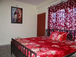 a bedroom with a red bed with a red bedspread at ValleyView Rooms with Homely Ambience in Shimla