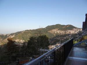 a balcony with a view of a mountain at ValleyView Rooms with Homely Ambience in Shimla