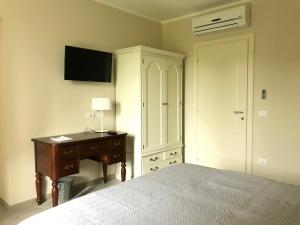 a bedroom with a bed and a desk and a cabinet at Agriturismo La Rinaldina in Faenza