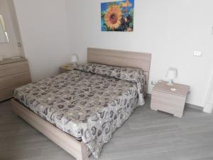 um quarto com uma cama e uma cómoda e uma mesa de cabeceira em Palazzo dei Vespri em Caltagirone