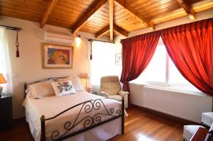 a bedroom with a bed and red curtains at Villa Lagonisi 1 in Lagonissi