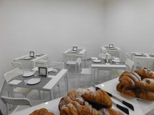 a bunch of tables and chairs with pastries on them at Palazzo dei Vespri in Caltagirone