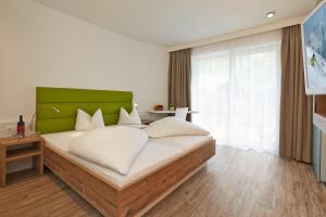 a bedroom with a large bed with a green headboard at A Casa Alpendiamond in Sölden