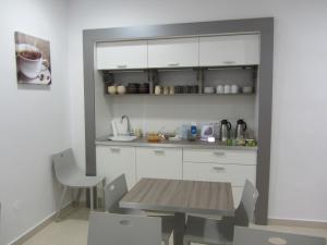 uma cozinha com armários brancos e uma mesa de madeira em Villa Tollazzi em Logatec