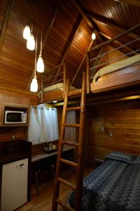 a room with two bunk beds and a desk at Casa na Árvore in Santa Cruz do Sul