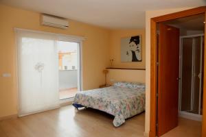 a bedroom with a bed and a sliding glass door at Llucmajor 29 in Mahón