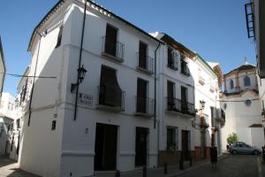 un edificio blanco con puertas y ventanas negras en una calle en Casa Rural Villalta, en Priego de Córdoba