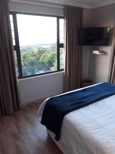 a hotel room with a bed and a large window at Westbrook Place in Westbrook