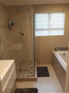 a bathroom with a shower and a bath tub at Westbrook Place in Westbrook