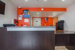 an empty waiting room with an orange wall at Motel 6-Ventura, CA - Downtown in Ventura