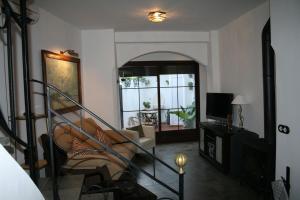 a living room with a spiral staircase and a television at Casa Rural Villalta in Priego de Córdoba