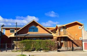 a wooden house with a fence in front of it at Hostal Fernando de Magalhaes in Punta Arenas