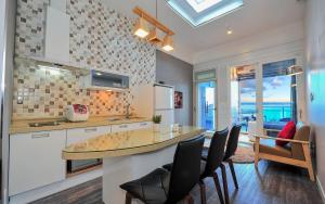 a kitchen with a counter with chairs and a table at Sokcho Esher House Pension in Sokcho