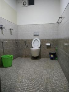 baño con aseo y cubo verde en CL Dreams Homestay, en Kochi