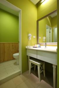 a bathroom with a sink and a toilet and a mirror at Flying Cow Ranch in Tongxiao