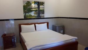 a bedroom with a bed and a picture on the wall at Motel Hoang Gia in Long Khanh