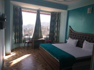 una camera con un letto e una grande finestra di Peaceful & scenic Homestay in Shoghi-Shimla a Shimla