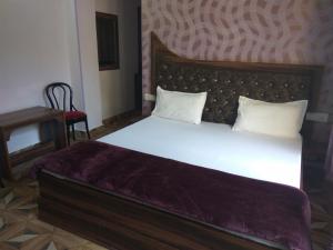 a bedroom with a large white bed and a chair at Peaceful & scenic Homestay in Shoghi-Shimla in Shimla