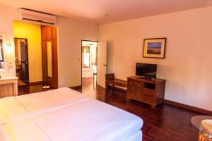a hotel room with a bed and a television at Coco Palm Beach Resort - SHA Extra Plus in Mae Nam