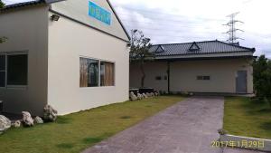 a white building with a sign on the side of it at Tianyuan Nanwan Homestay in Nanwan